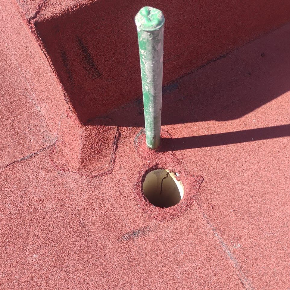 Detalle de bajada de agua pluvial sellada sobre acabado de gravilla ceramizada