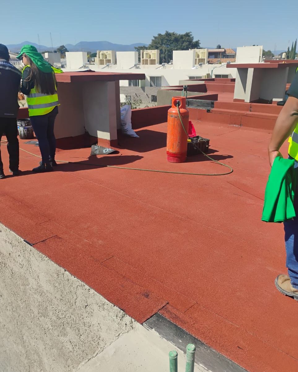 Cuadrilla de aplicadores trabajando en una azotea con producto Curacreto